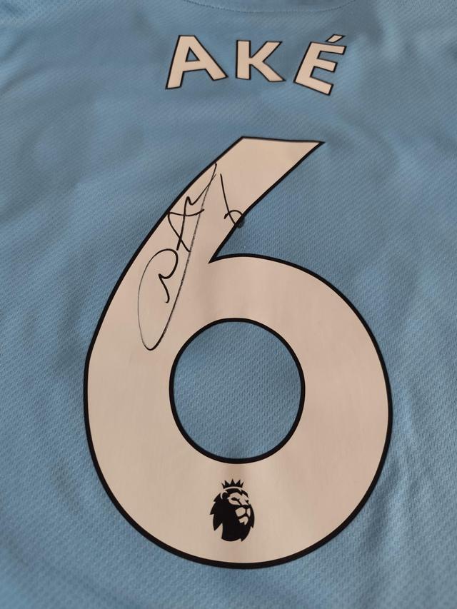 Gesigneerd Ake Manchester City shirt.